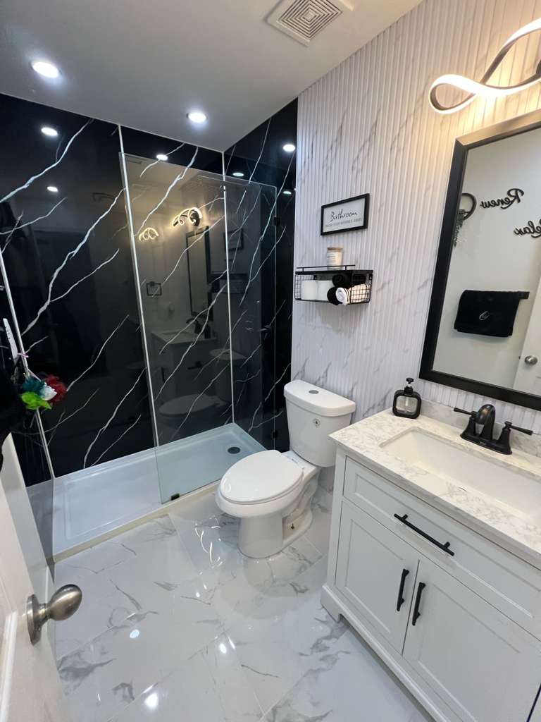 Baño remodelado con mármol PVC negro