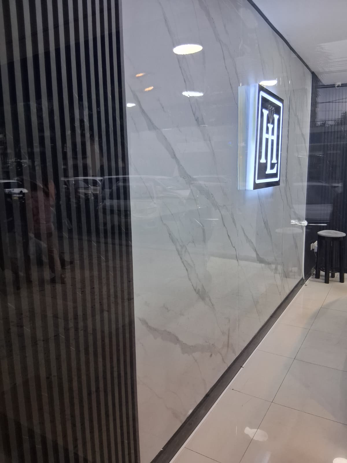 Fachada de local comercial revestida en mármol PVC blanco y panel de lamas