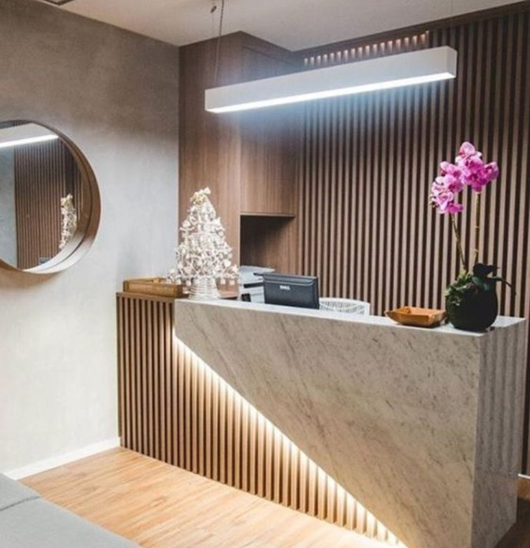 Recepción con muro de WPC y panel de mármol PVC con luz LED integrada